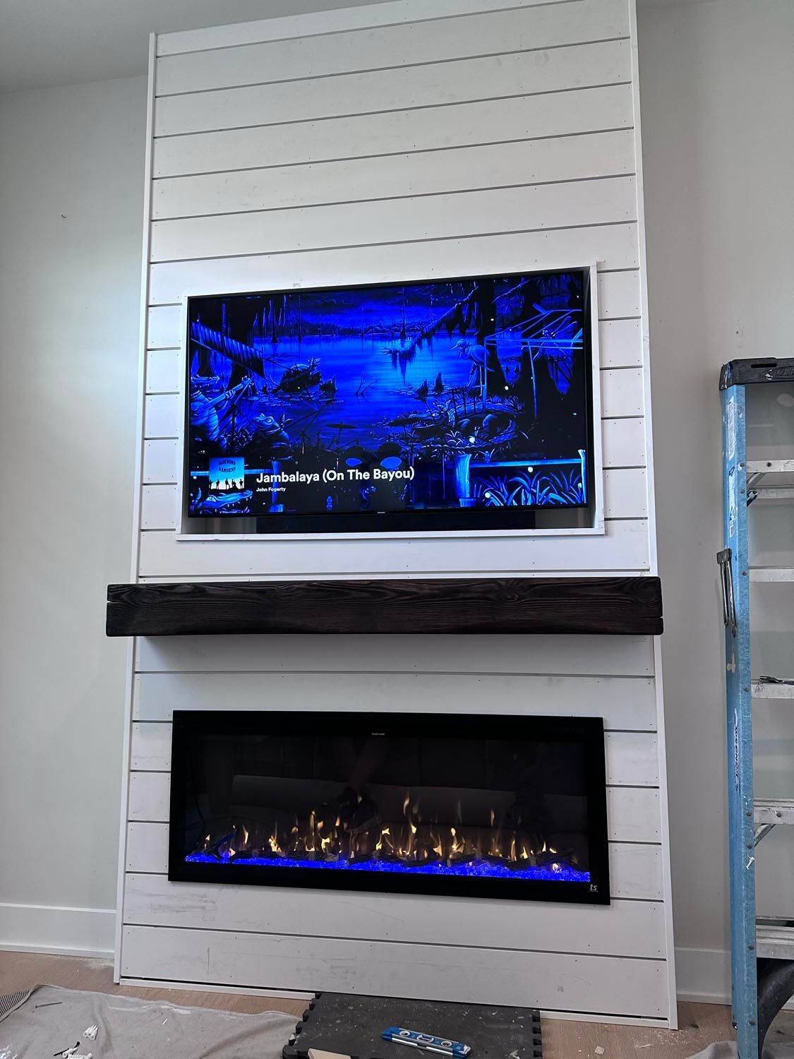 A fireplace with a flat screen tv mounted above it.