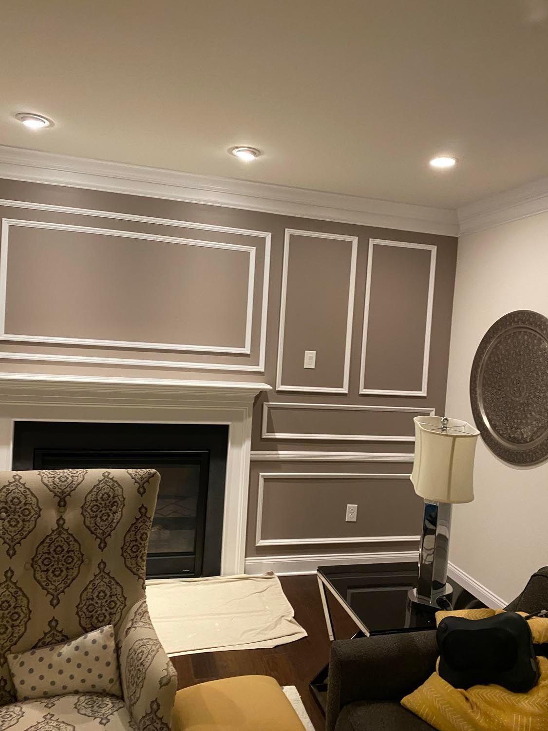 A living room with a couch , chair , lamp and fireplace.