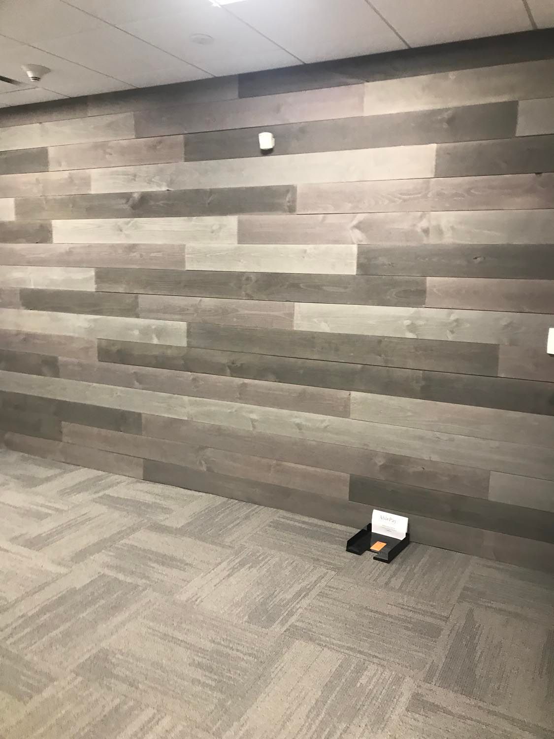 A room with a wooden wall and a carpeted floor.