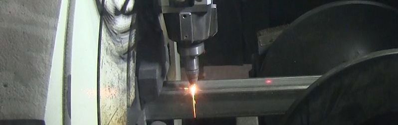 Laser cutting metal in a workshop, sparks visible.
