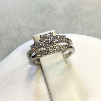 A wedding ring and engagement ring are stacked on top of each other