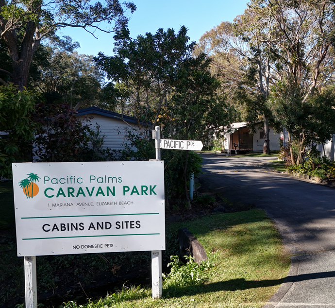 A small house with a porch and a table and chairs on it — Pacific Palms Caravan Park in Elizabeth Beach, NSW