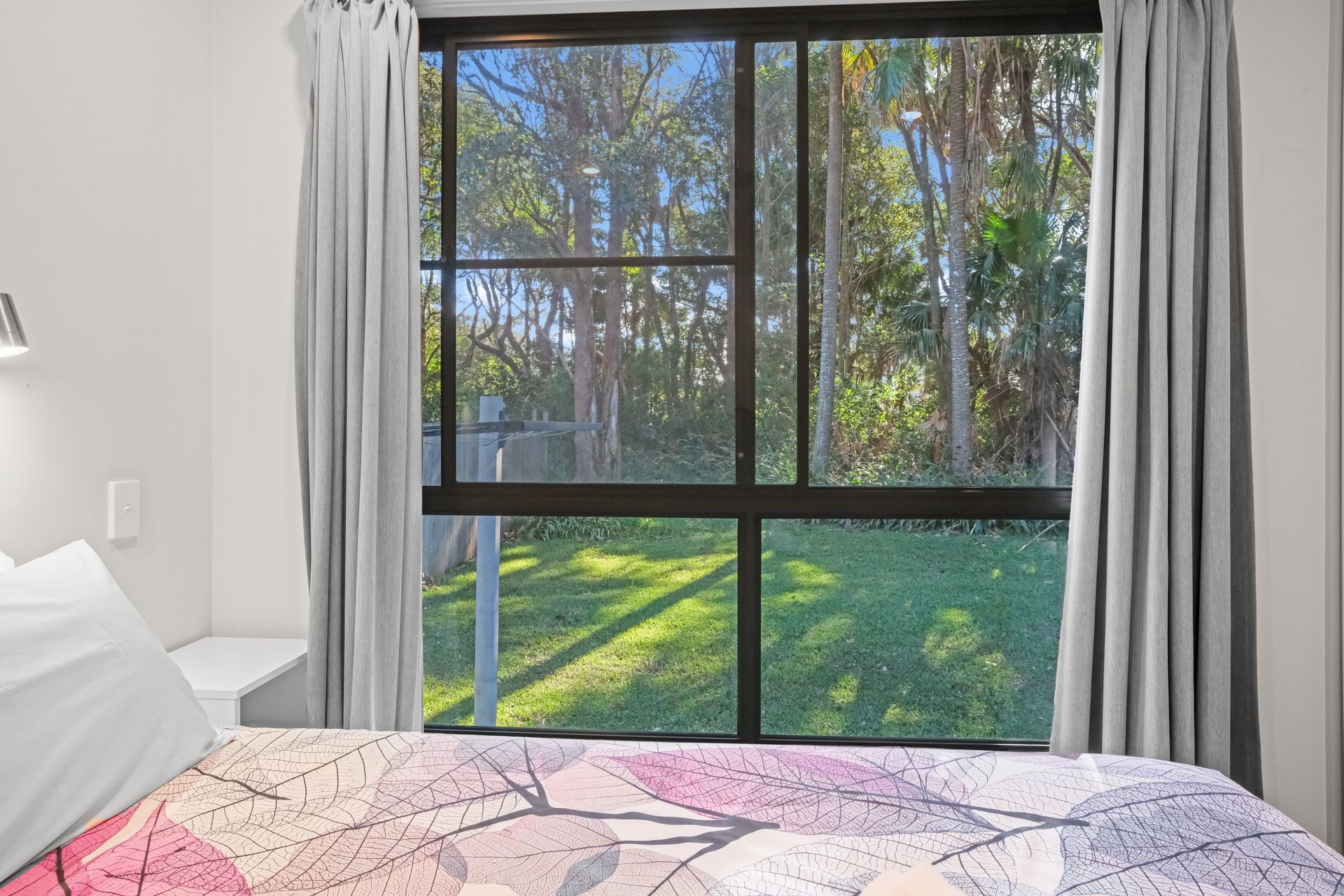 A Pair Of Blue Curtains Are Hanging On A Window In A Living Room — Pacific Palms Caravan Park in Forster, NSW