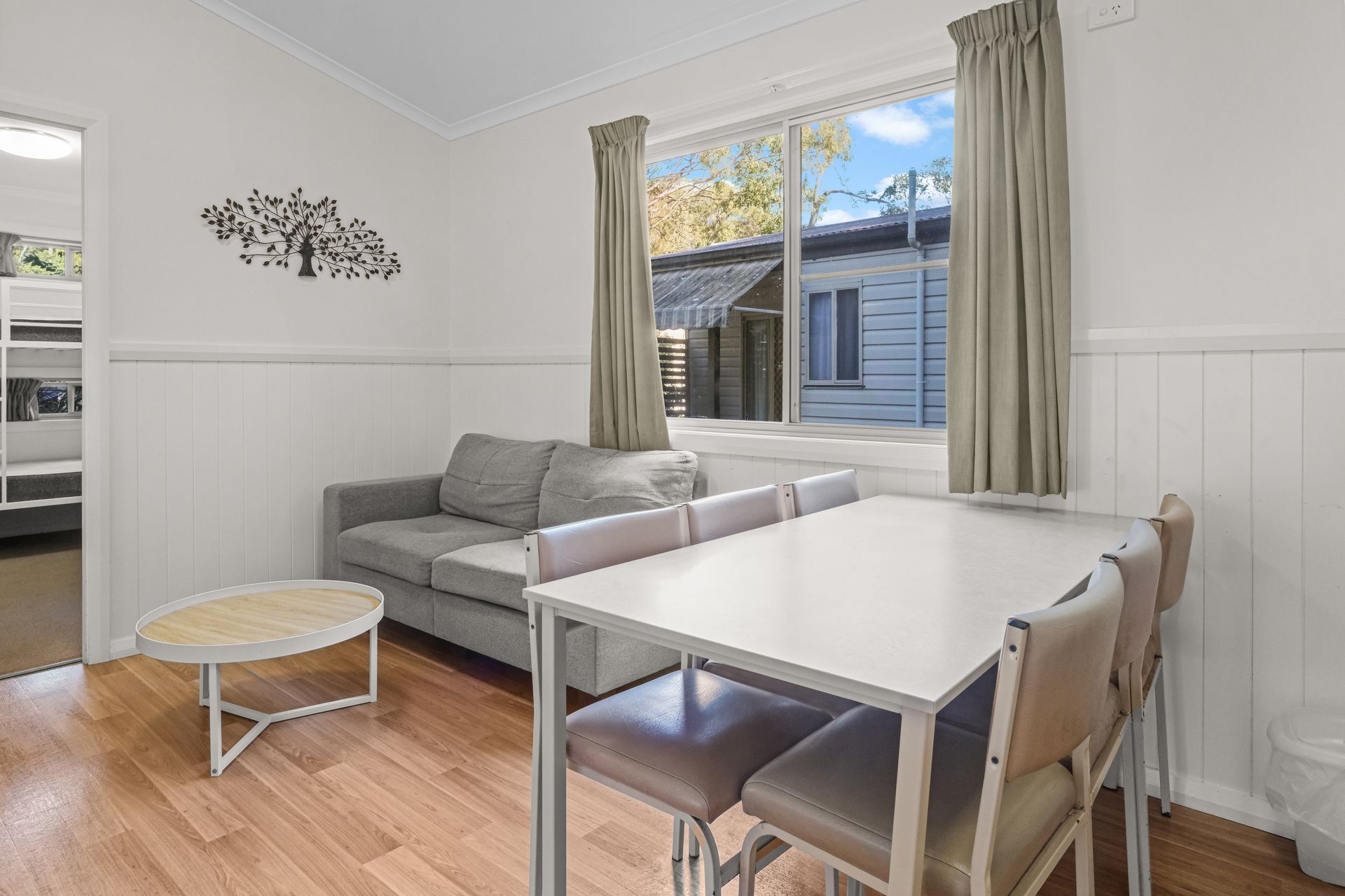 A Bedroom With A Bed, A Window And A Painting On The Wall — Pacific Palms Caravan Park in Elizabeth Beach, NSW