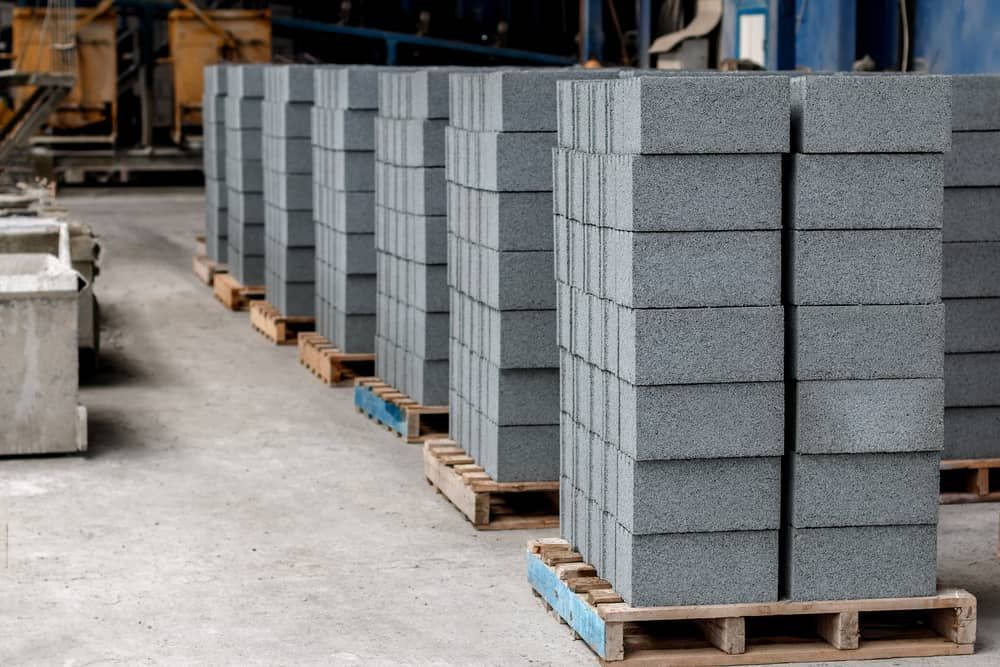 A Warehouse Filled With Stacks Of Concrete Blocks On Wooden Pallets — Mascrete Pty Ltd In Hermit Park, QLD