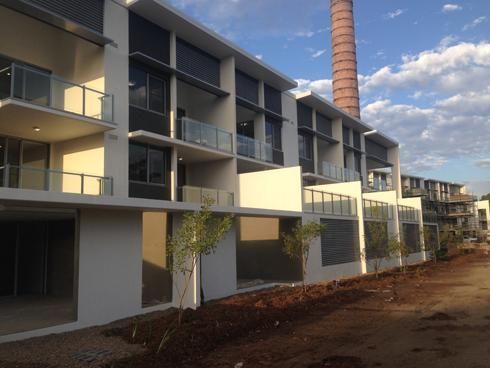 A Building With Balconies And A Chimney In The Background — Mascrete Pty Ltd In Hermit Park, QLD