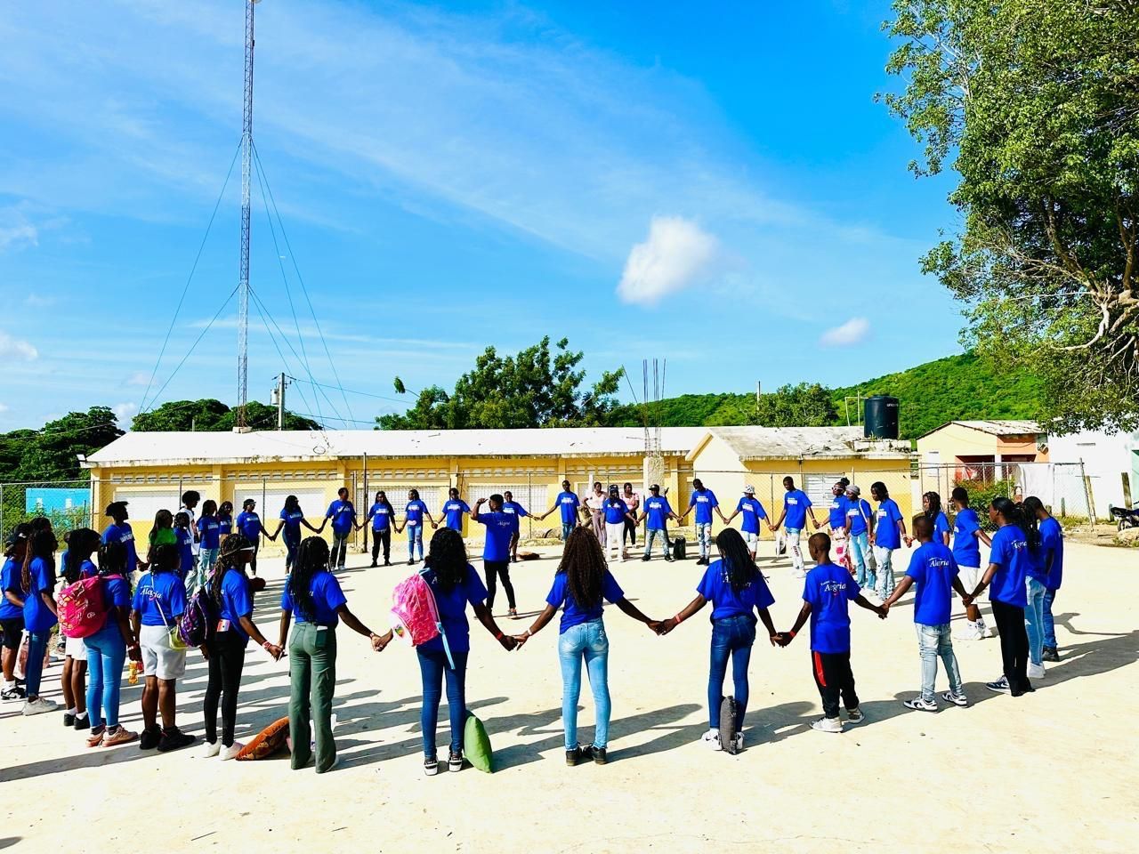 A group of people are standing in a circle holding hands.