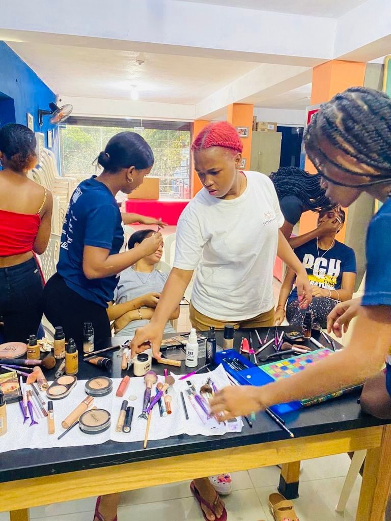 A group of people are sitting around a table with makeup.