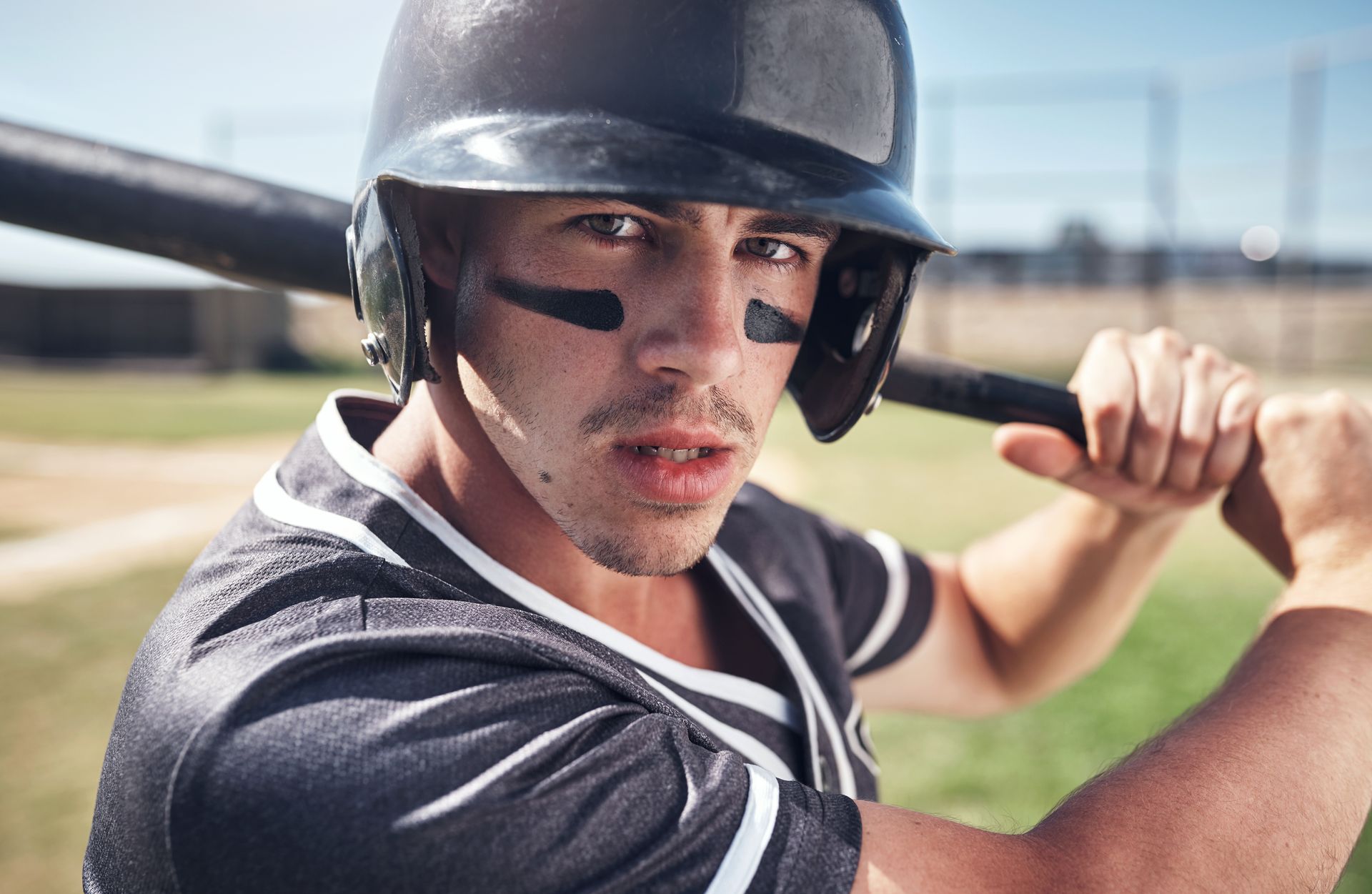 Baseball player at bat, wearing helmet and eye black, holding bat, focused expression.