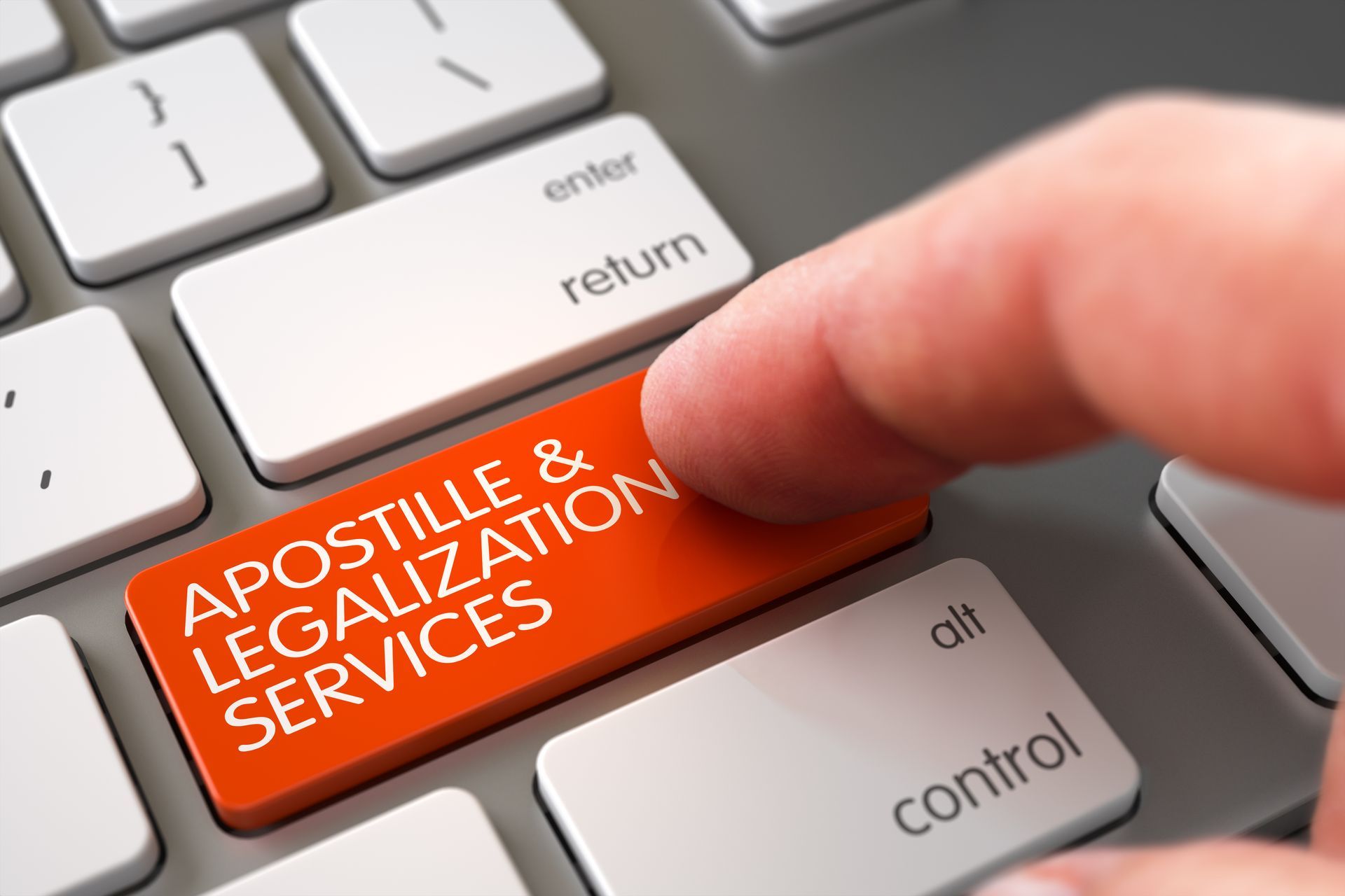 Hand pressing red “apostille & legalization services” key on a keyboard