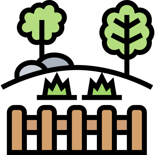 A fence with trees and rocks in the background.