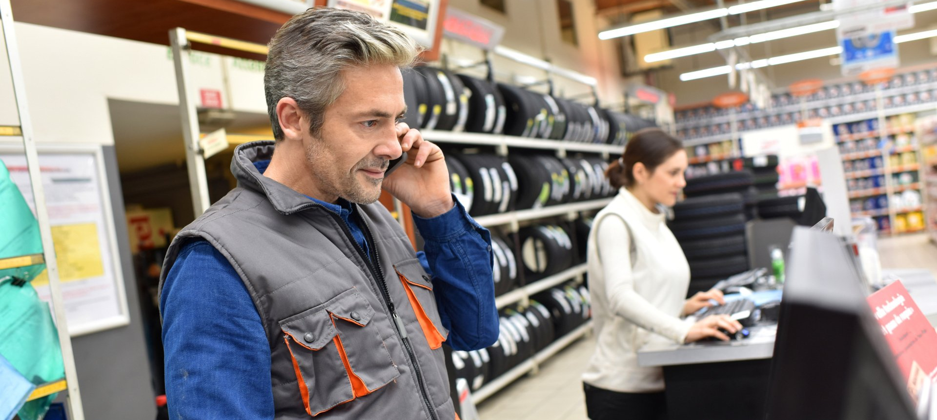 A man is talking on a cell phone in a store.