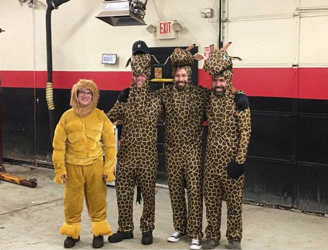 A group of people in giraffe costumes are posing for a picture