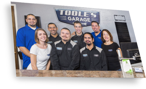A group of people standing in front of a sign that says tools garage
