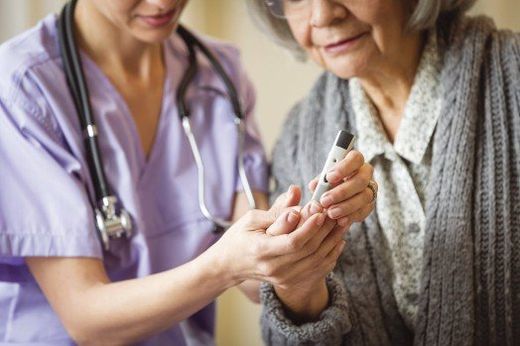 Female Nurse Helping Elderly Woman