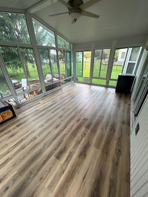 A man is laying tiles on the floor with a trowel.