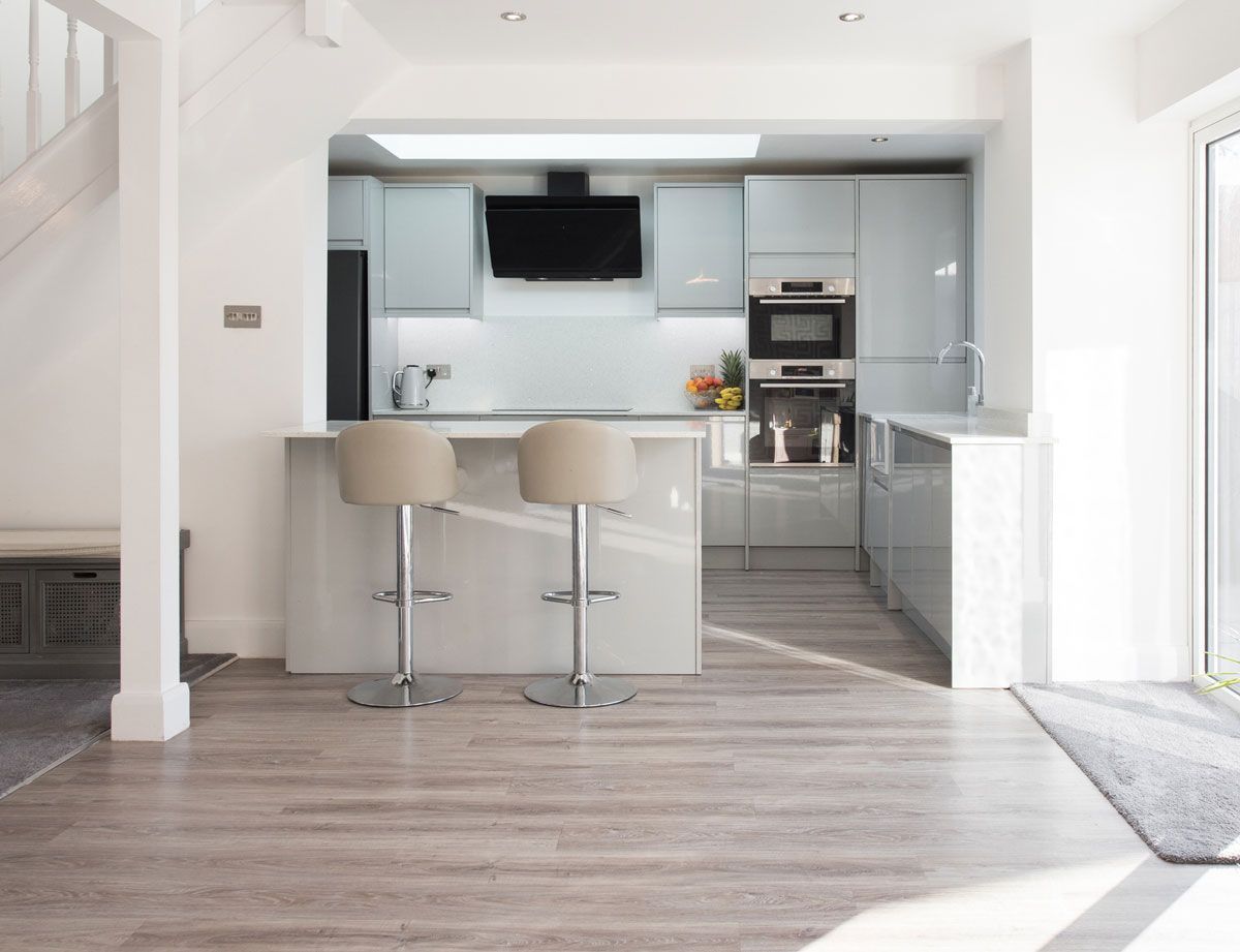 A kitchen with two bar stools and a staircase