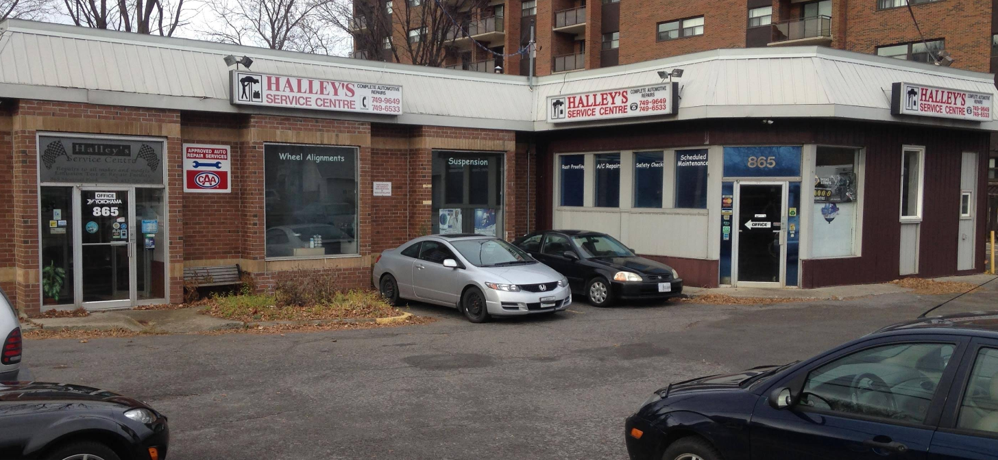 Exterior of a brick building with two businesses; cars parked in front.
