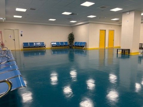 Una sala d'attesa con sedie blu e pavimento blu.