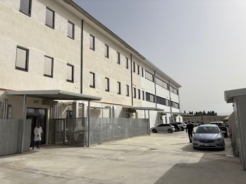 Un grande edificio con le auto parcheggiate davanti.