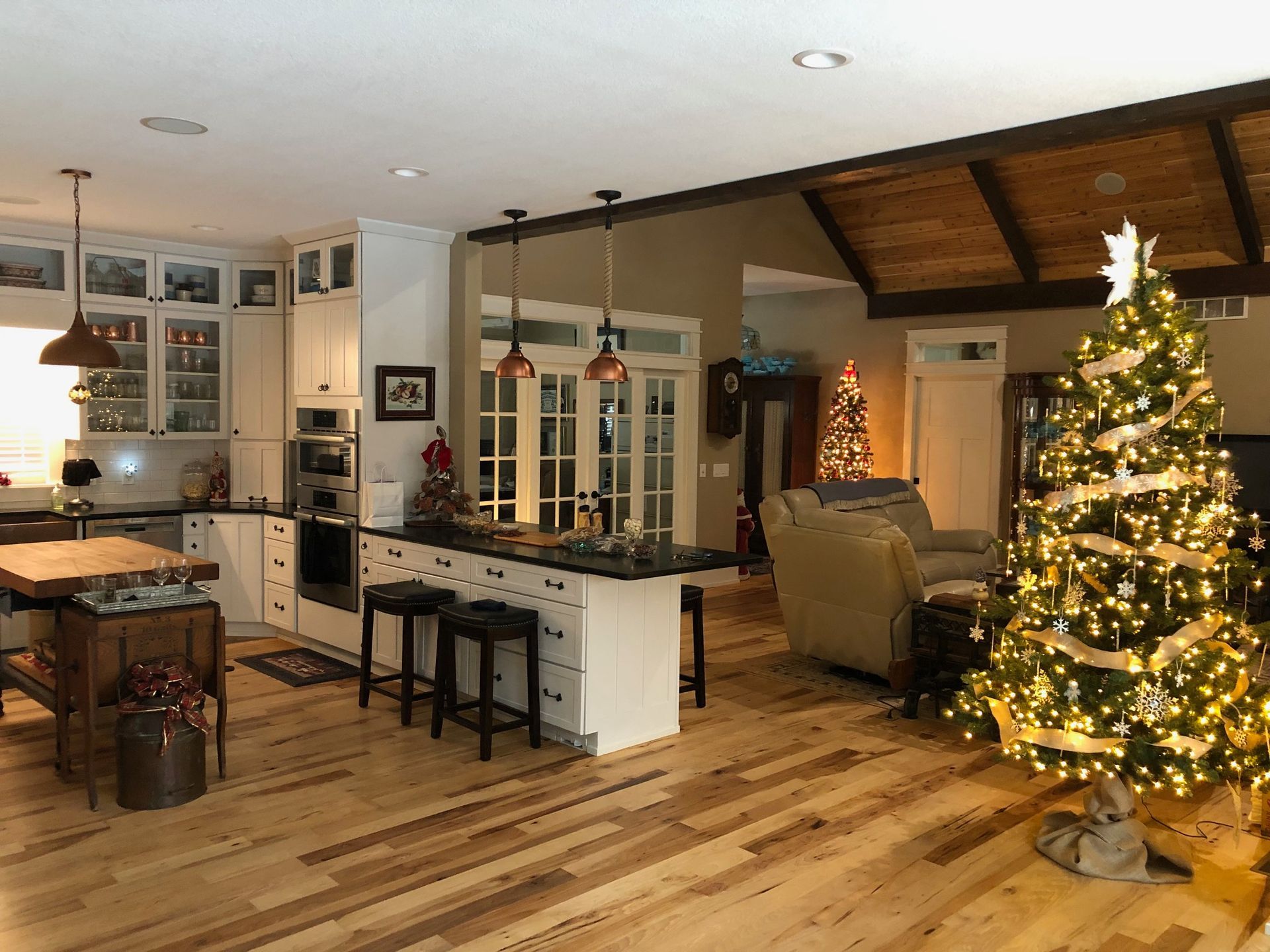 There is a christmas tree in the middle of the living room.