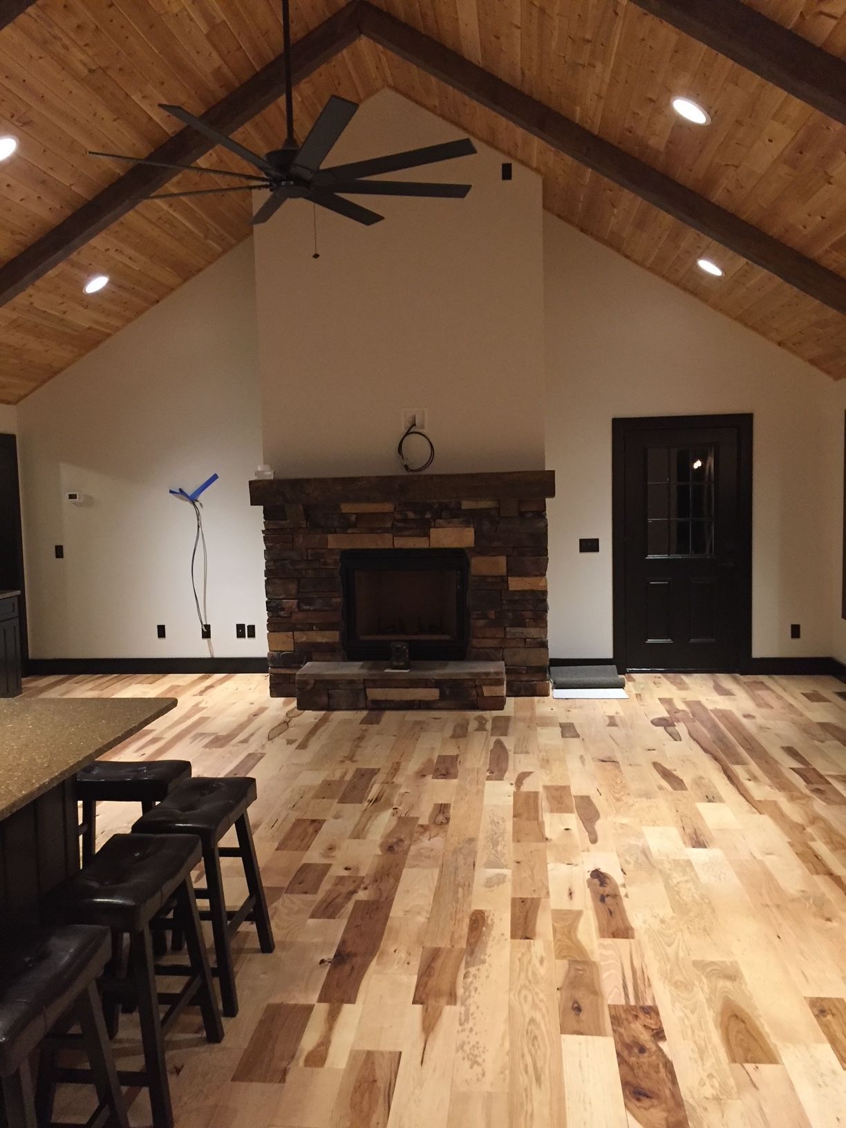 A living room with a fireplace and a ceiling fan