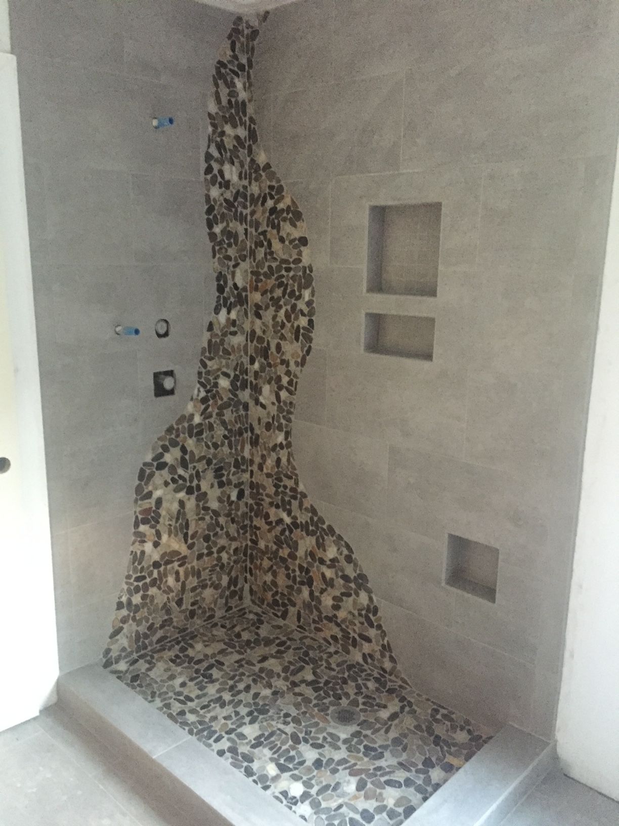 A shower with a mosaic design on the floor