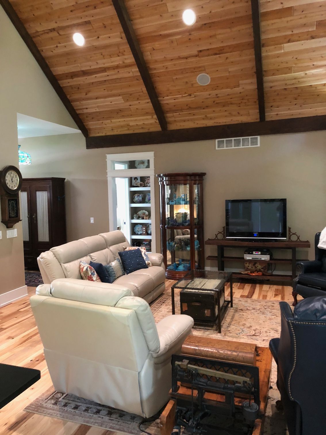 A living room with a couch , chairs , coffee table and television