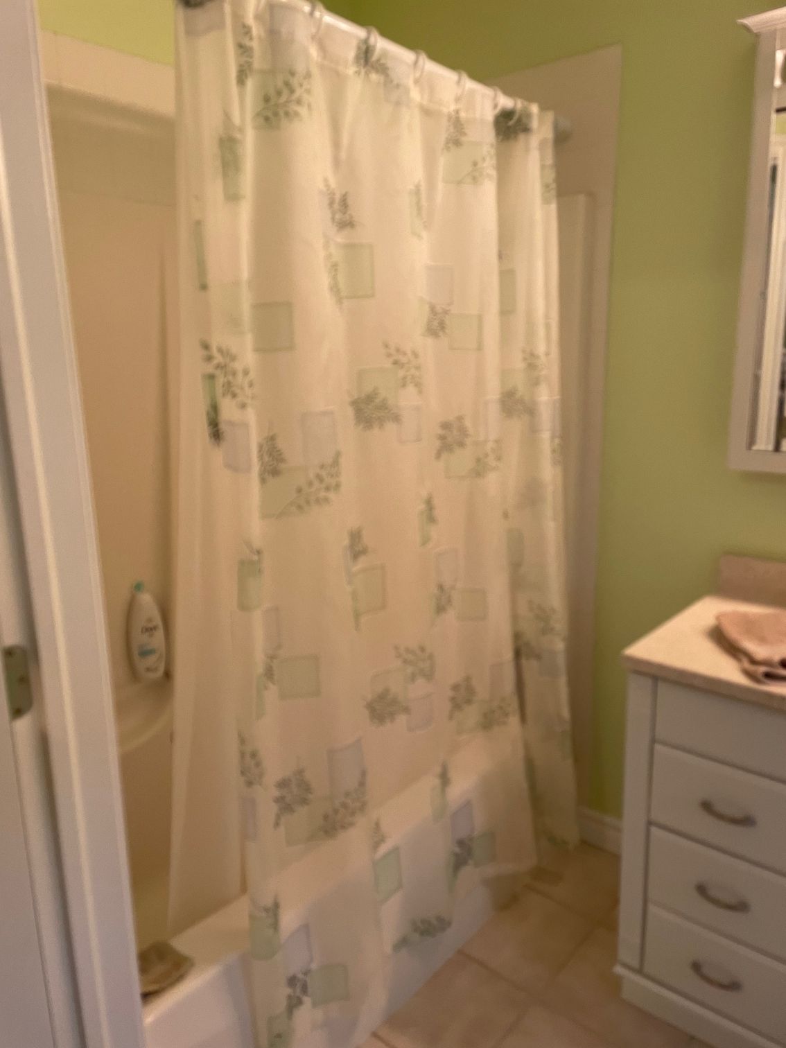 A bathroom with a shower curtain and a sink.