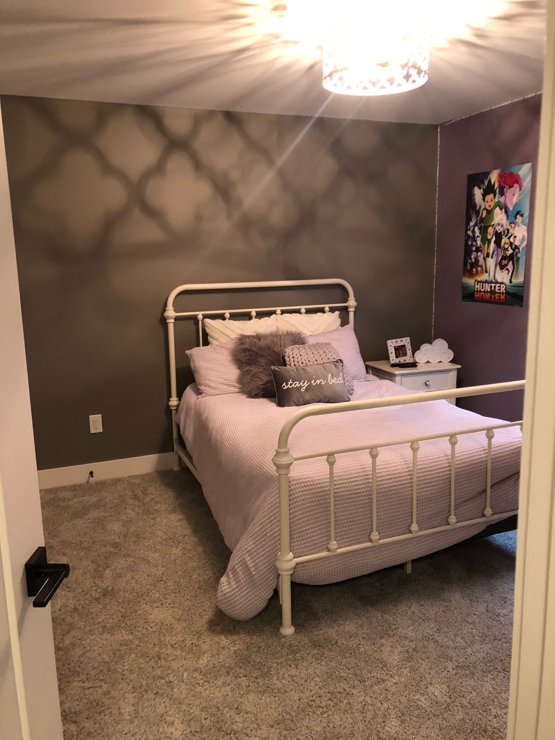 A bedroom with a bed , nightstand , and painting on the wall.