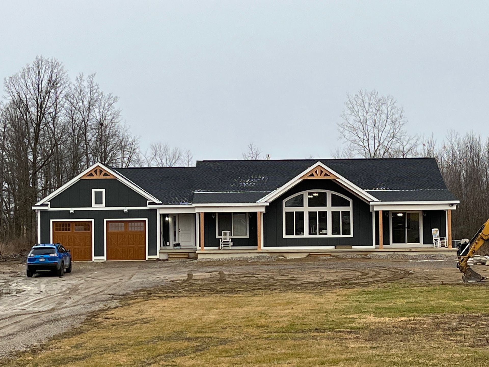A large house with a blue car parked in front of it