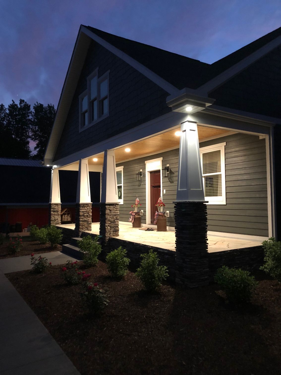 A house with a porch is lit up at night