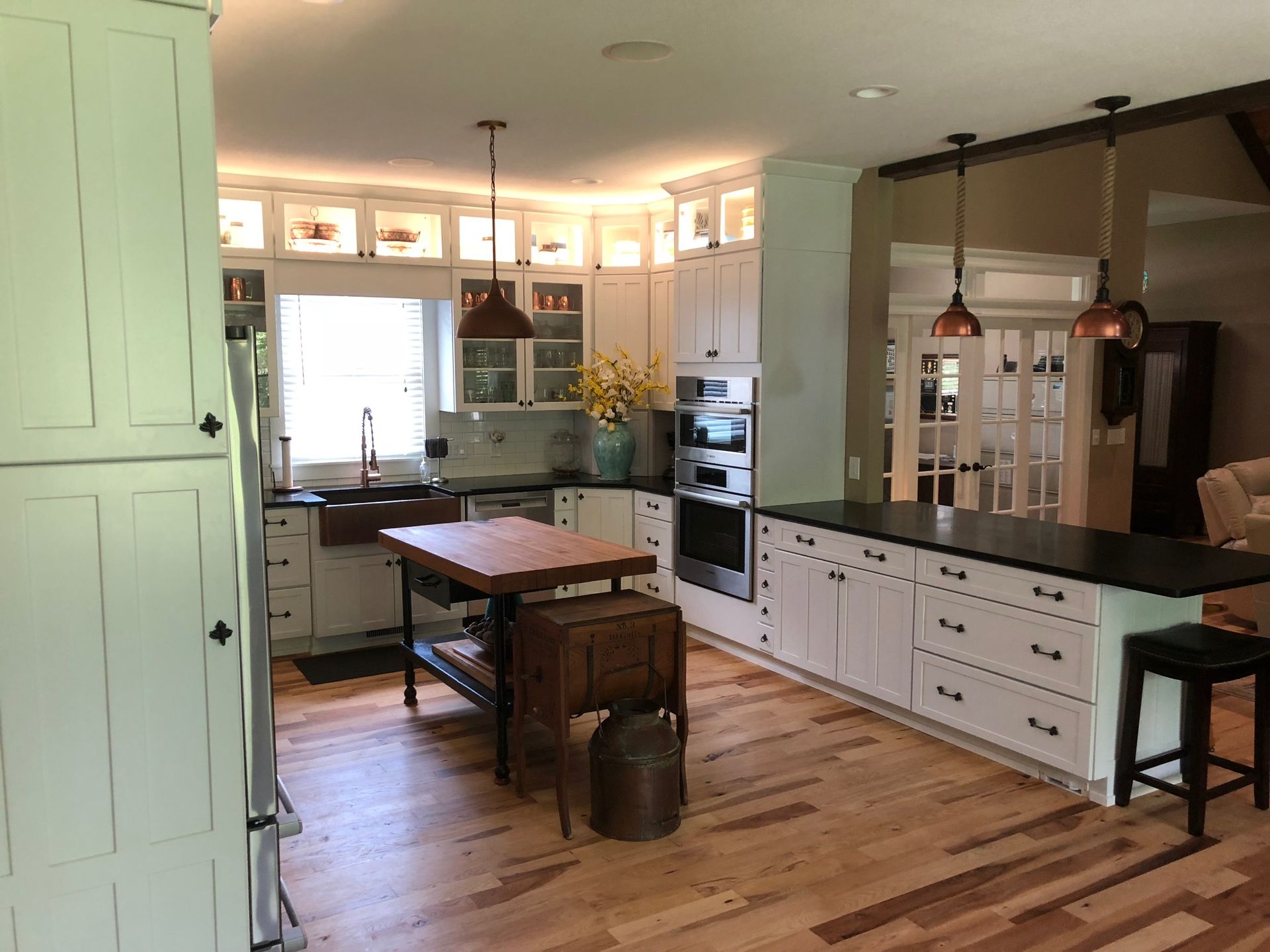 A kitchen with white cabinets and wooden floors