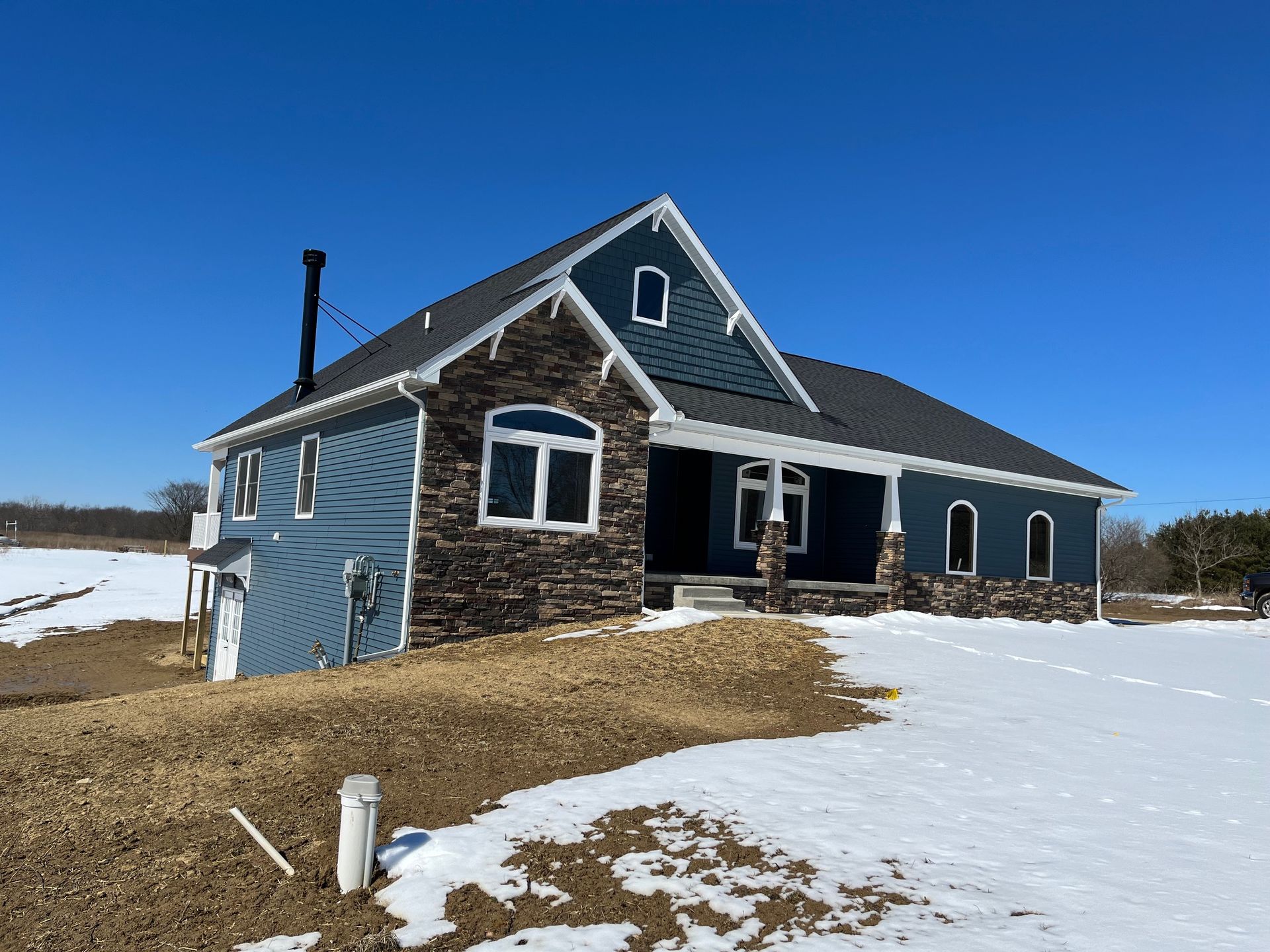 A house is sitting in the middle of a snowy field.