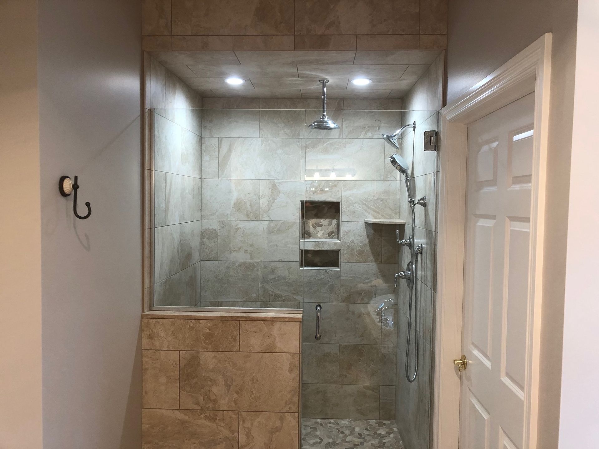 A bathroom with a walk in shower and a door