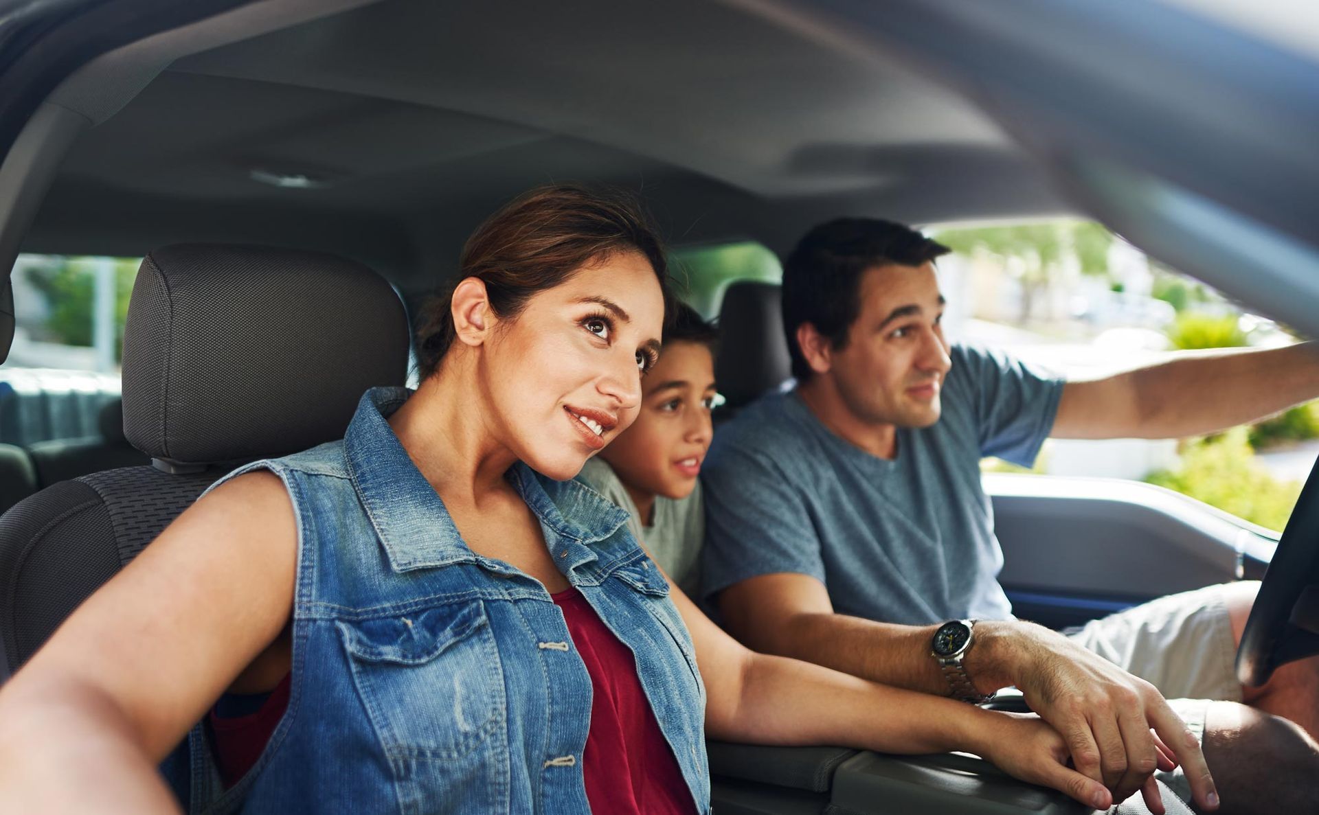 A blue subaru outback is parked in front of a building.