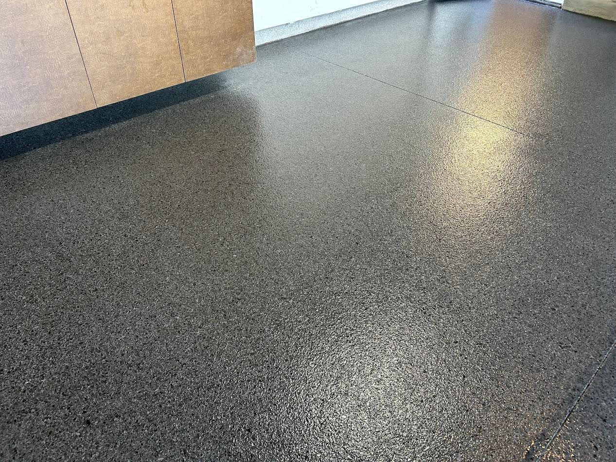 A person is standing on a concrete floor next to a vacuum cleaner.