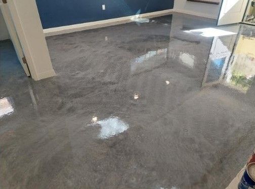 A shiny concrete floor in a room with a blue wall.