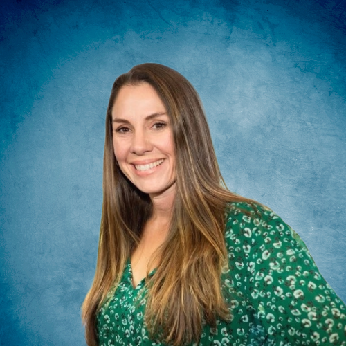 A woman in a green leopard print shirt is smiling in front of a blue background.