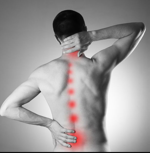 A man is holding his neck and back in pain.