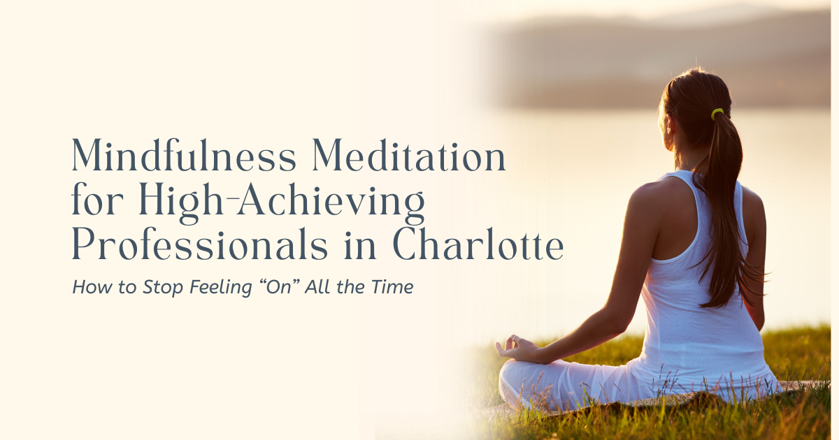 Woman sitting in meditation pose outdoors at sunset by a calm waterfront.