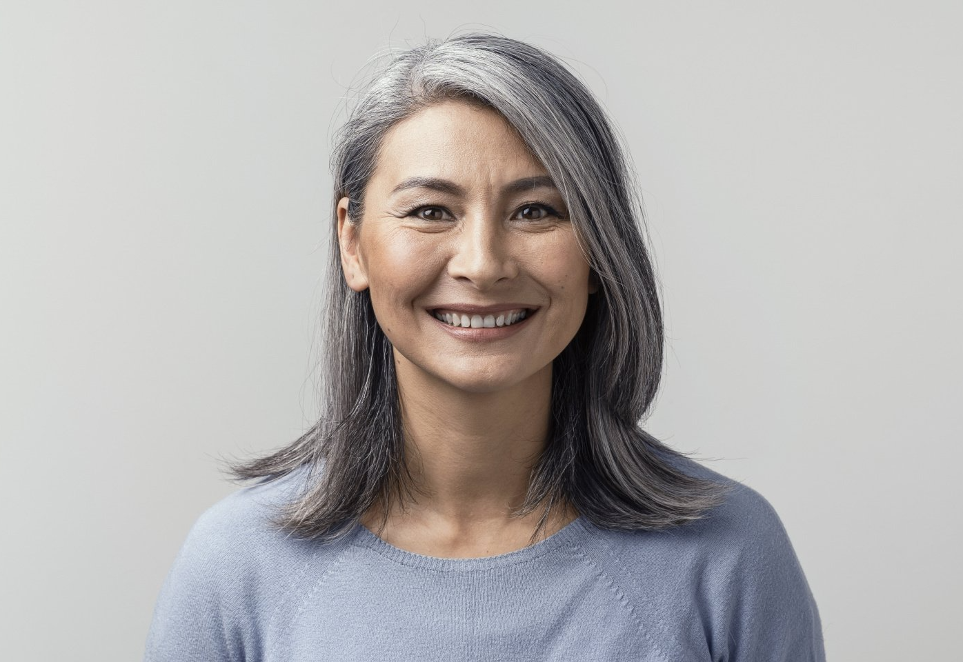 beautiful smiling mature woman against grey background