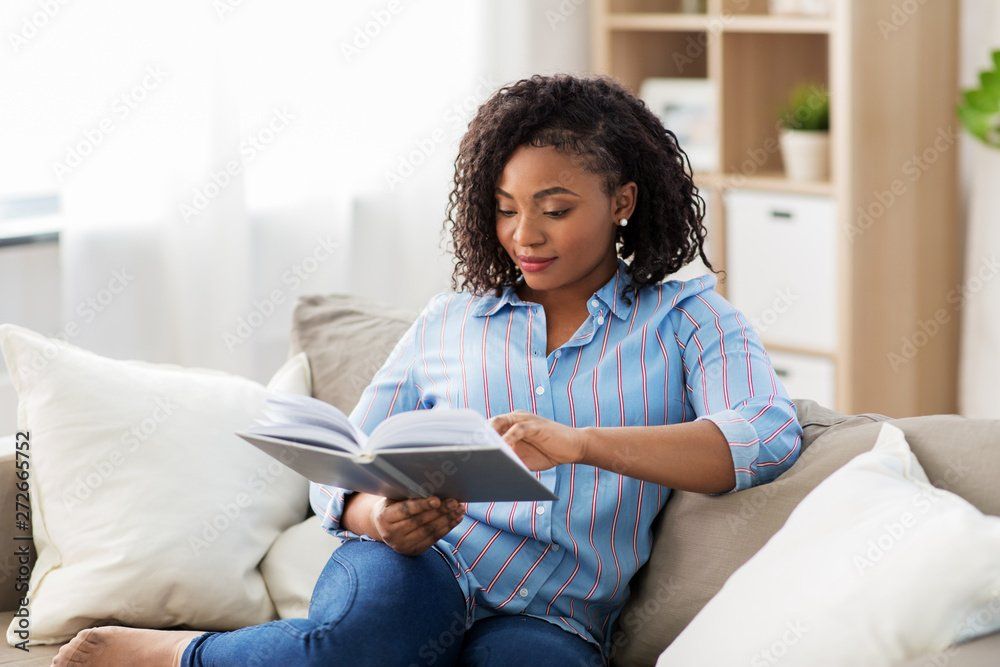 woman at home reading book on the couch