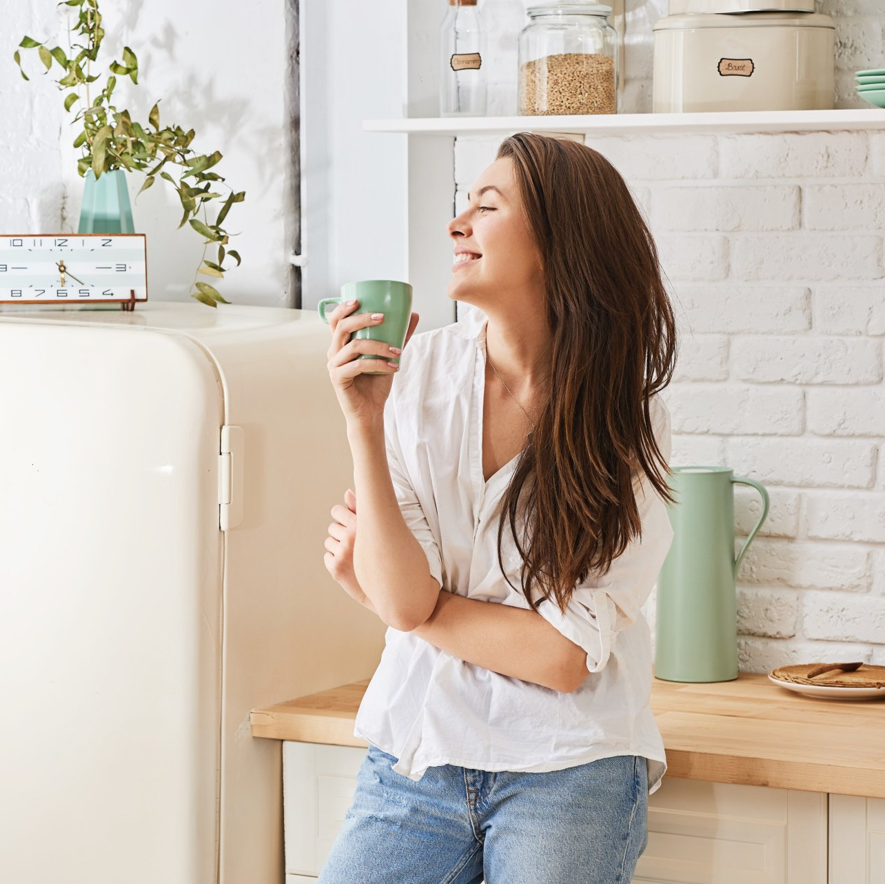 woman drinking coffee in her kitchen