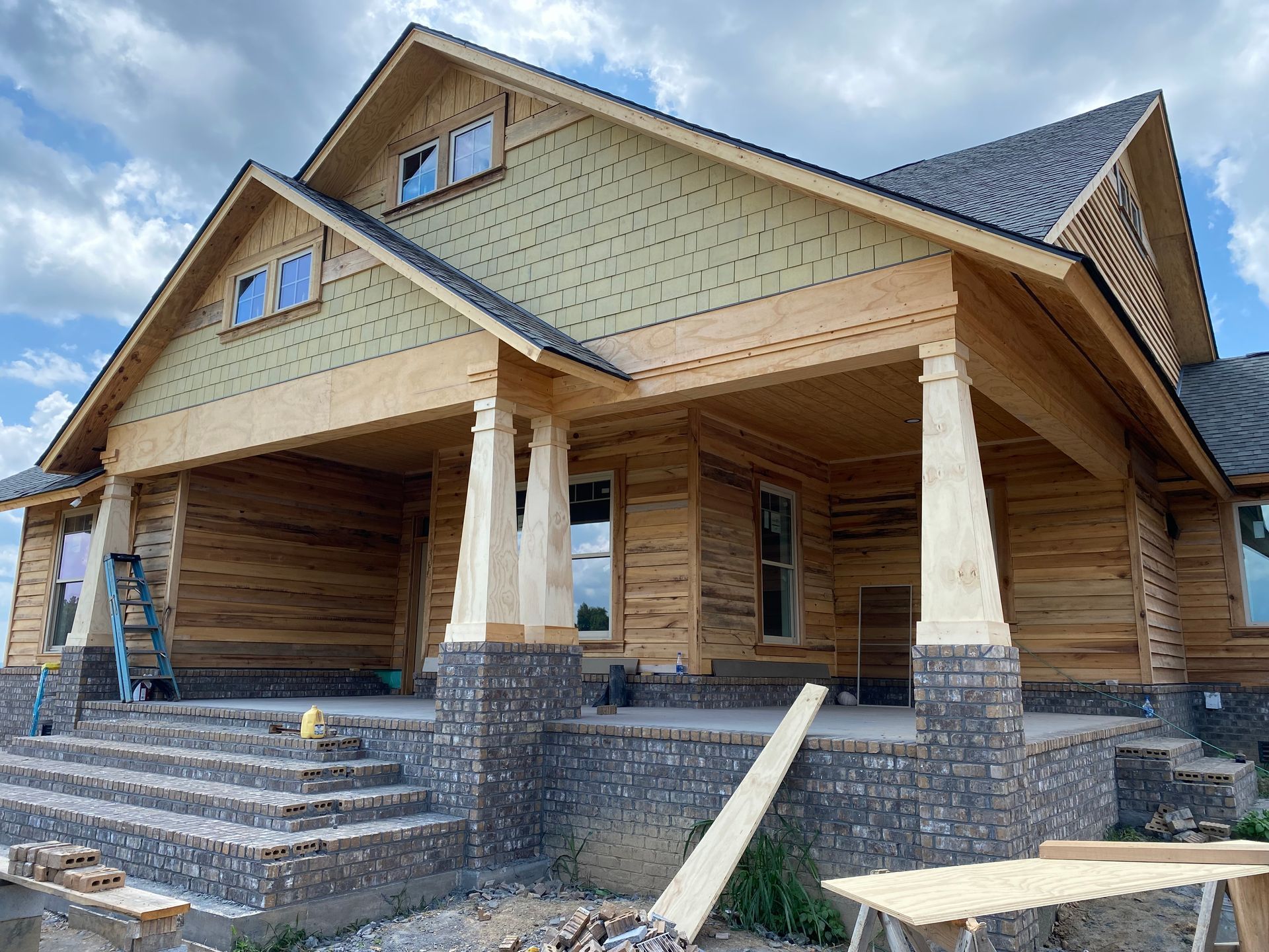 New log house under construction with stone porch and front steps