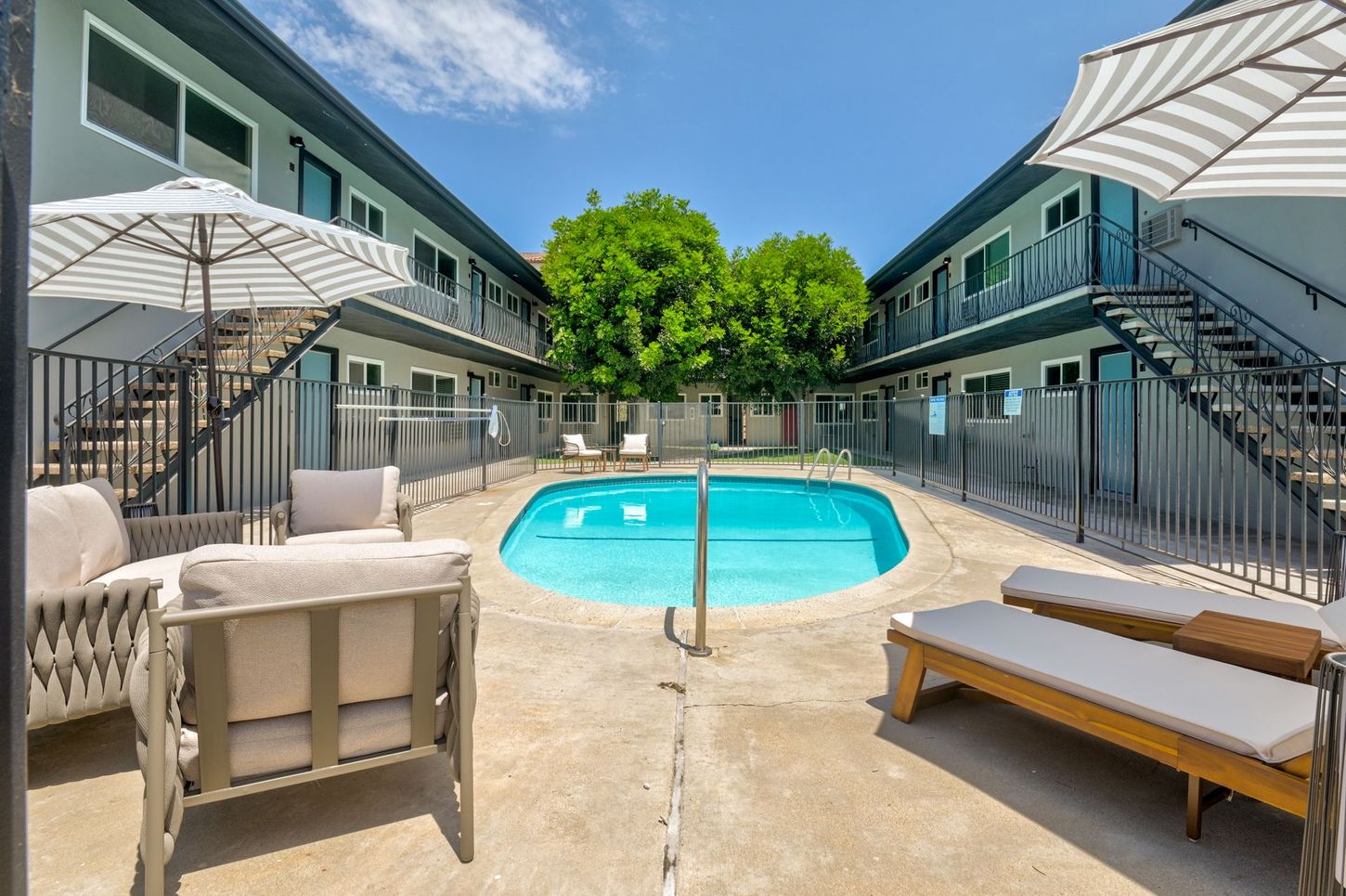 alternate photo showing the pool, featuring outdoor furniture