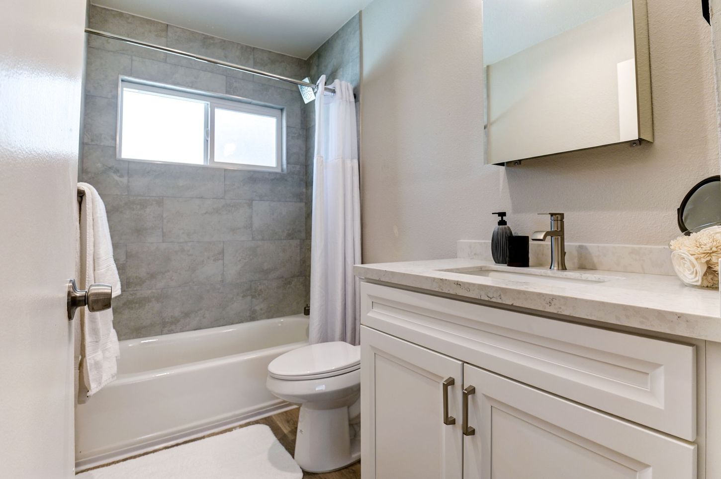 photo showing the restroom, featuring a shower/tub combination