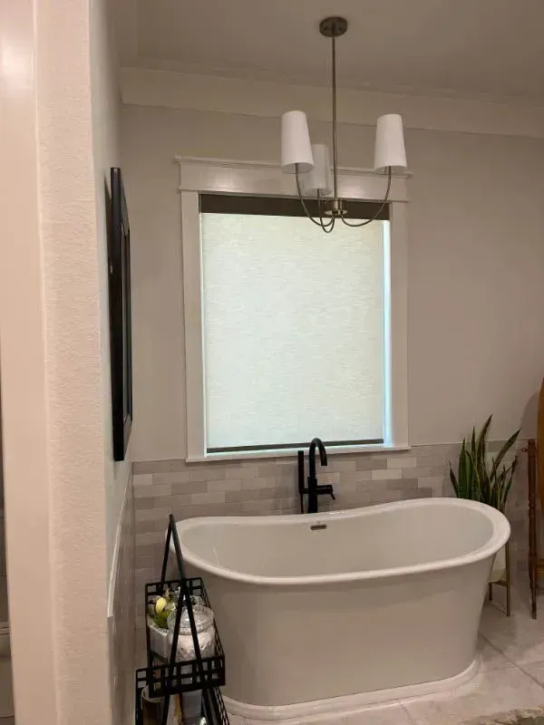 A bathroom with a bathtub and a window. Love is Blinds Arizona (844) 936-2446