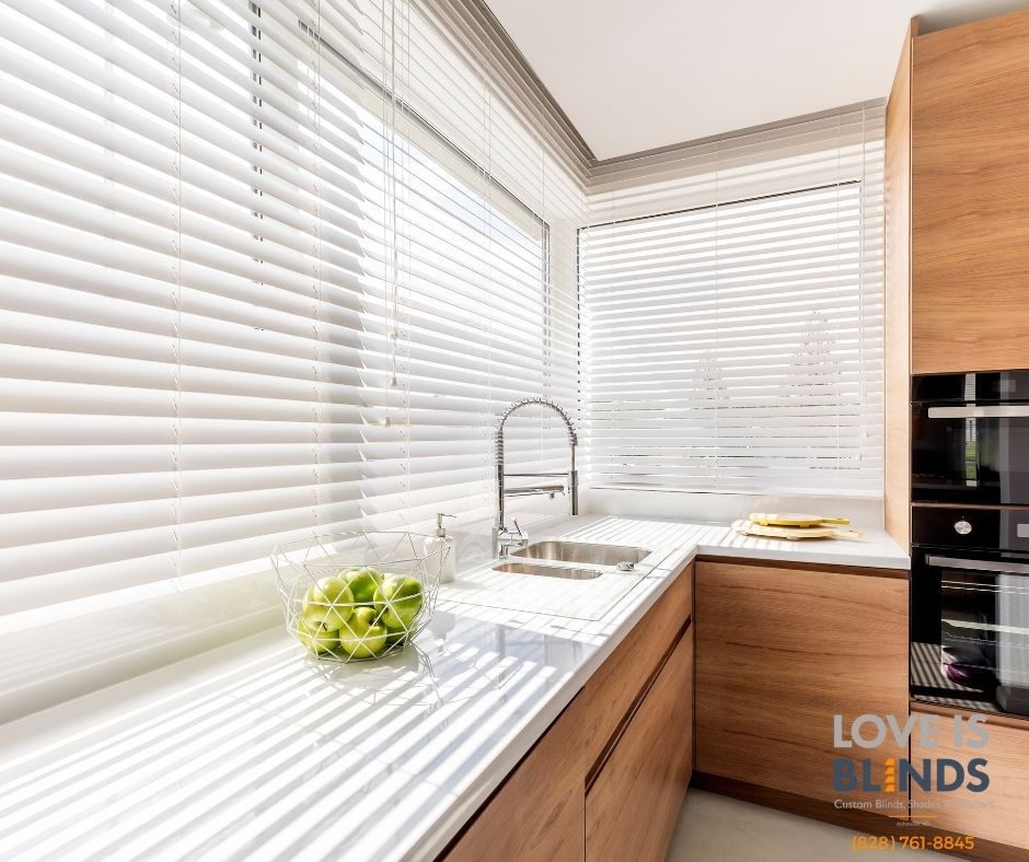 Bright kitchen with white blinds, countertop, and wood cabinets, with a sink and fresh apples.