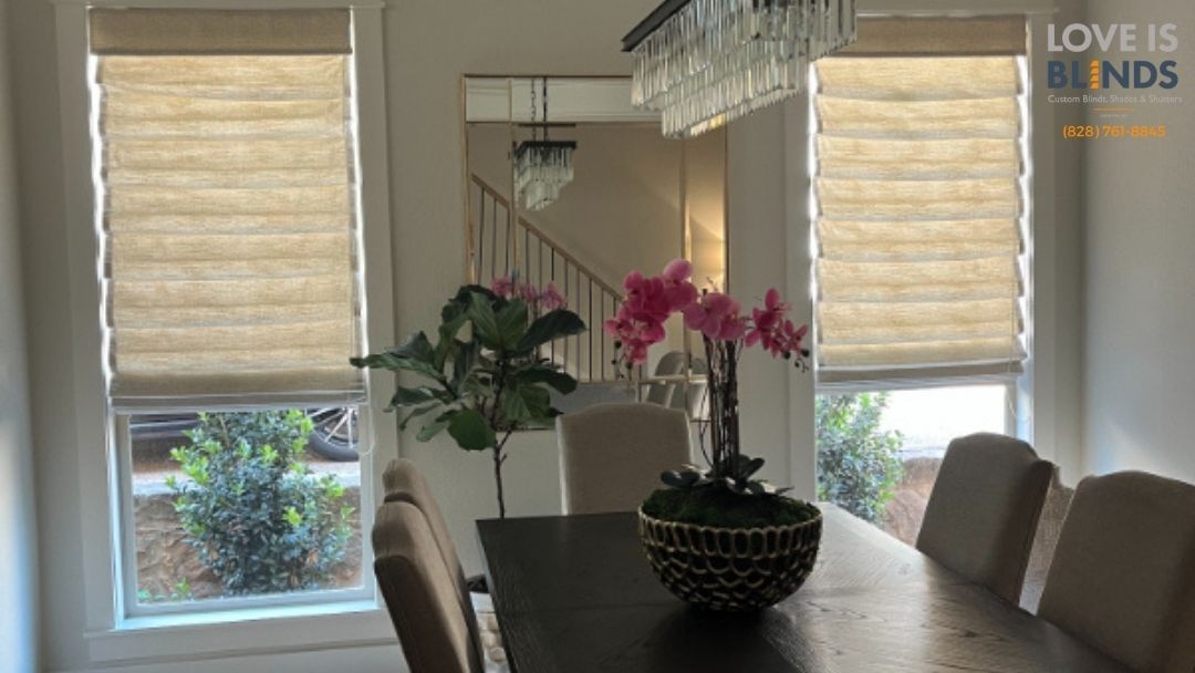 Dining room with closed tan window shades, a dark table, and pink orchids.